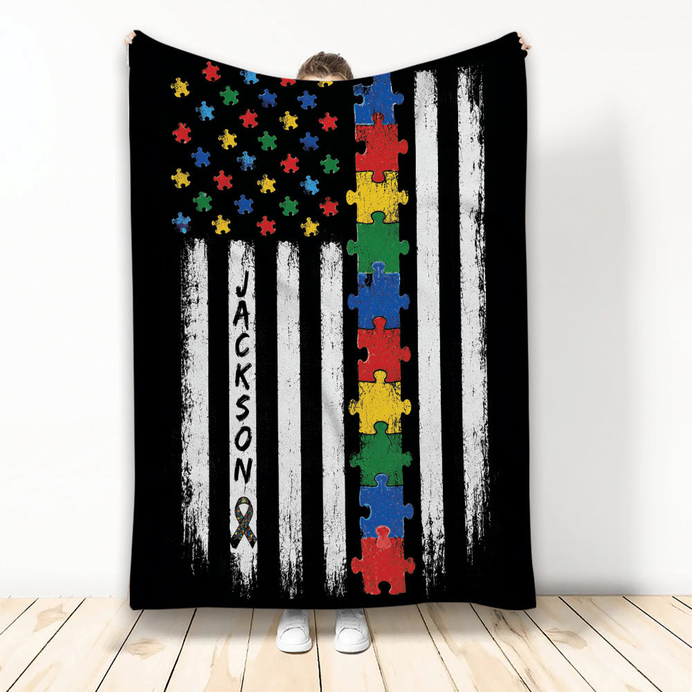 Autism awareness throw blanket with colorful puzzle pieces, black and white stripes, and an awareness ribbon