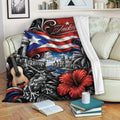 Puerto Rico blanket displayed on a sofa with island flag artwork, tropical hibiscus, historic buildings, and a guitar
