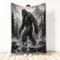 Bigfoot throw blanket displayed vertically with grayscale mountain, forest, waterfall, and wilderness artwork
