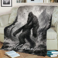 Grayscale Bigfoot blanket styled on a couch with mountain, forest, waterfall, and wilderness scenery