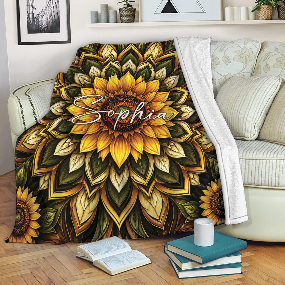 Sunflower throw blanket displayed on a sofa with rich golden petals and dark botanical artwork