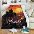 Western cowboy throw blanket draped over a sofa with horseback rider and sunset mountain artwork