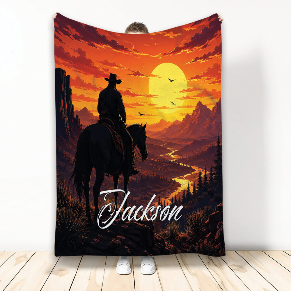 Cowboy throw blanket with horseback rider, mountain valley, glowing sunset, and western landscape artwork