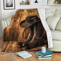 Western cowboy throw blanket displayed on a sofa with hat, boots, rope, and wood plank design
