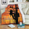 Lineman blanket draped over a sofa with utility pole artwork and a dramatic orange sunset scene