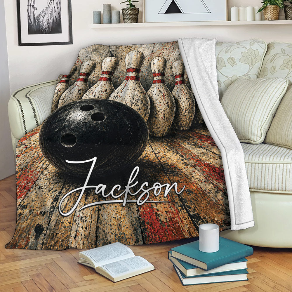 Bowling throw blanket displayed on a sofa with a black ball, pins, and warm vintage-style artwork