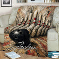 Close lifestyle view of a bowling blanket with striking pins, bowling ball, and textured red and black design