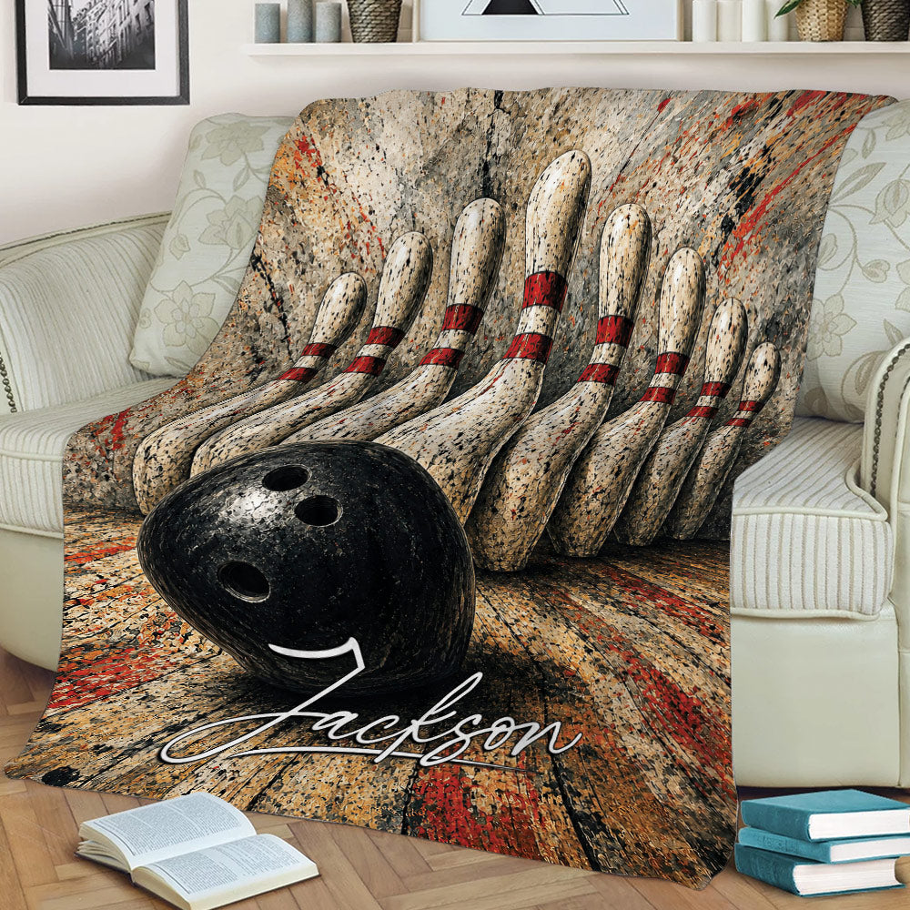 Close lifestyle view of a bowling blanket with striking pins, bowling ball, and textured red and black design
