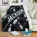 Bowling blanket draped over a sofa with black balls, white pins, and navy blue artwork