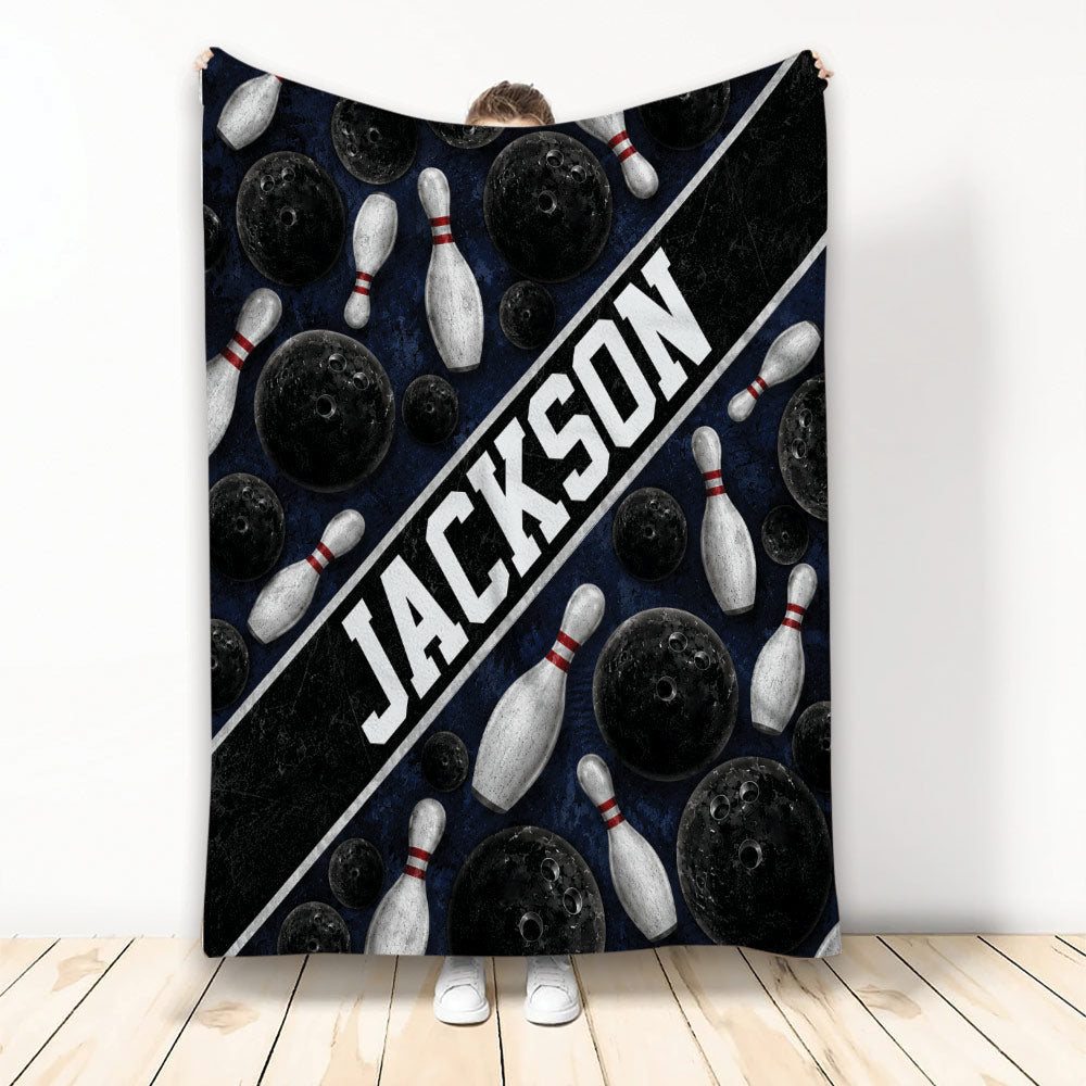 Bowling throw blanket with black bowling balls, white pins, and bold diagonal sports artwork