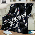 Bowling throw blanket displayed on a couch with pins, bowling balls, and bold graphic styling