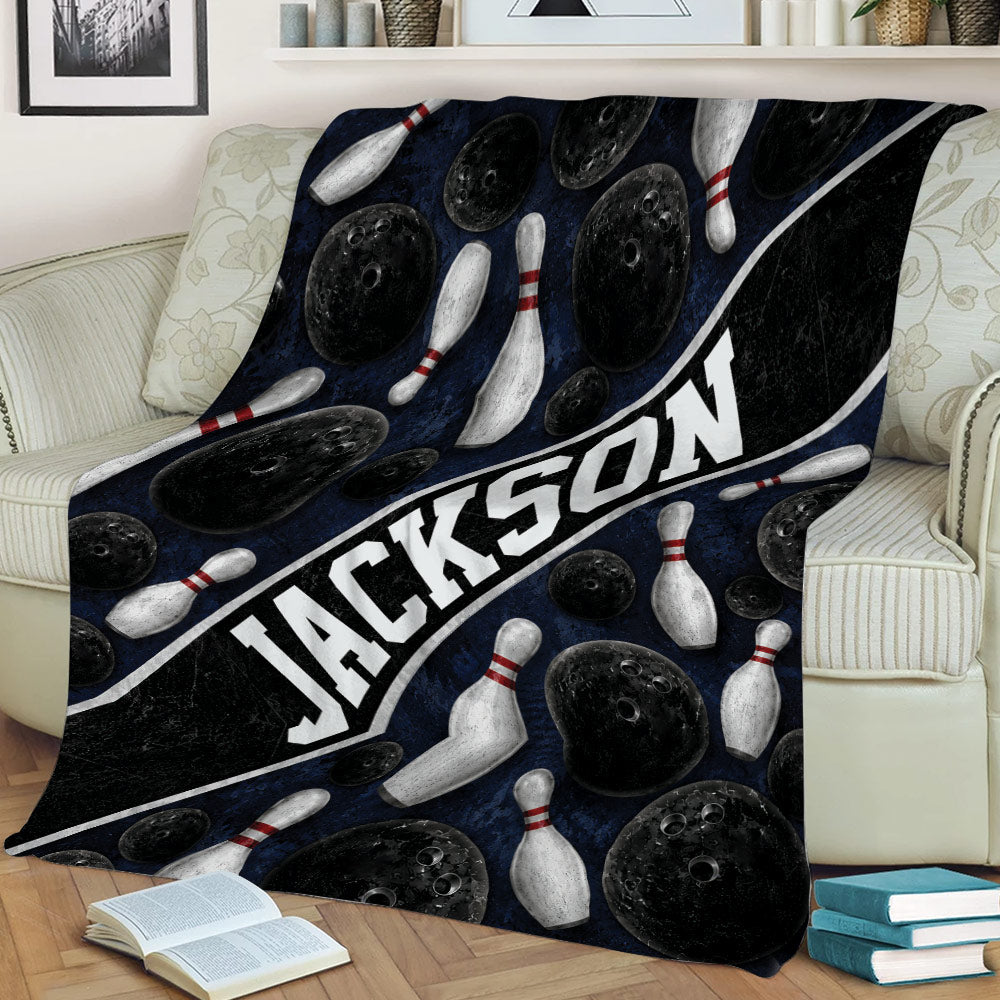 Bowling throw blanket displayed on a couch with pins, bowling balls, and bold graphic styling