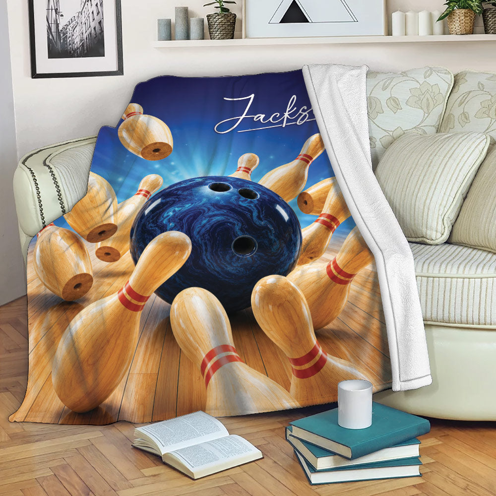 Bowling throw blanket draped over a sofa with blue ball and colorful pin artwork