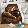 Bowling blanket draped over a sofa, featuring pins and a black bowling ball in warm brown tones