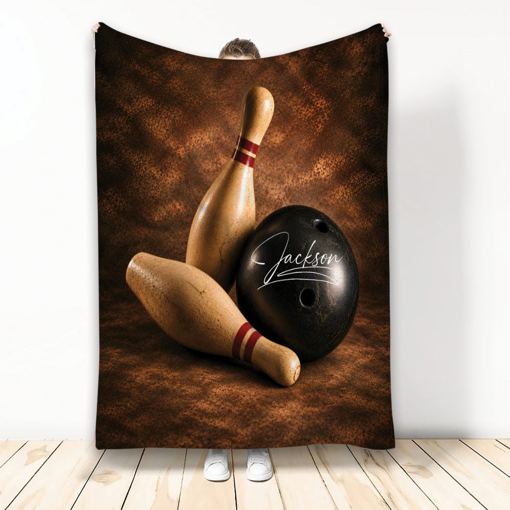 Bowling throw blanket featuring wooden pins and a black bowling ball on a rich brown textured background