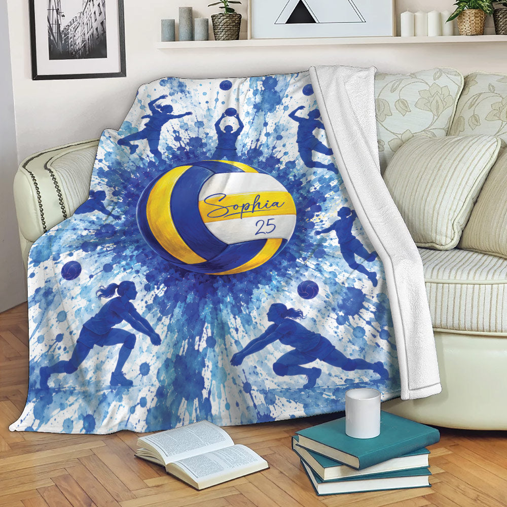 Blue and yellow volleyball throw blanket displayed across a sofa with energetic player silhouettes