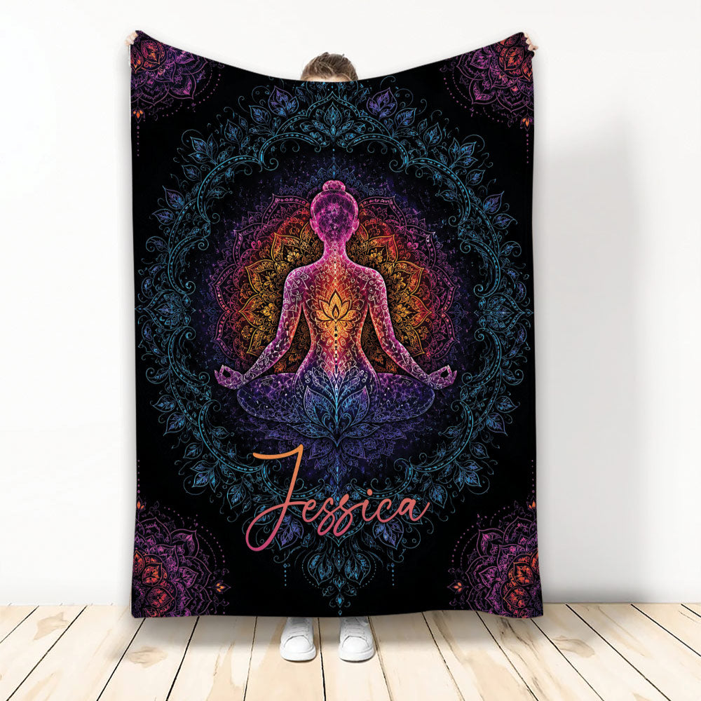Colorful yoga meditation figure and mandala artwork on a black throw blanket