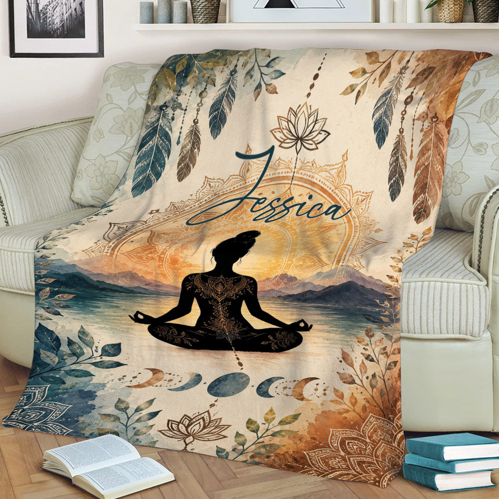 Meditation yoga throw blanket displayed on a couch with lotus, feather, mountain, and moon phase design