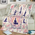 Yoga throw blanket displayed on a couch with lotus flowers, botanical details, and peaceful poses