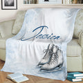 Winter ice skating blanket displayed on a couch with detailed skate illustrations and snowy blue artwork
