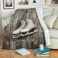 Ice skating blanket draped over a sofa with white figure skates and snowy rustic artwork