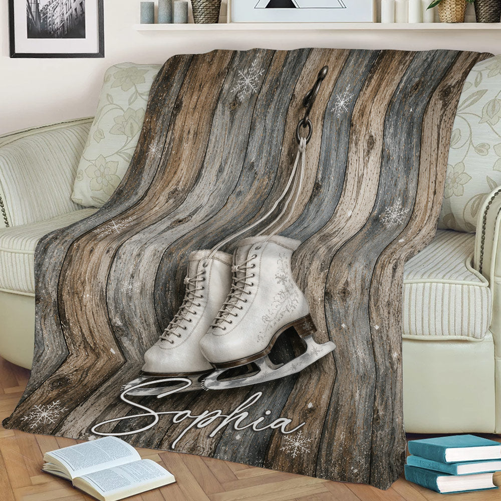 Ice skating throw blanket on a couch featuring white skates, snowflakes, and weathered wood texture