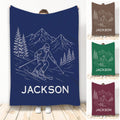 Navy skiing throw blanket featuring a line-art skier, mountain peaks, and evergreen trees
