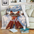Skiing blanket displayed on a sofa with skis, snowy mountains, and cozy winter scenery
