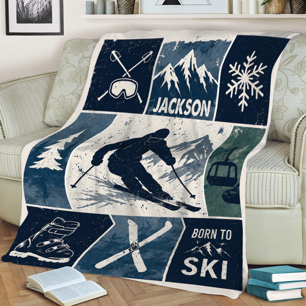 Skiing blanket draped over a couch featuring a skier, snowy mountain scene, ski boots, and blue winter artwork