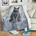Russian Blue cat blanket draped over a sofa with soft blue botanical watercolor design