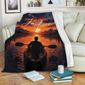 Kayak blanket displayed on a sofa with sunset lake, mountain and paddler artwork