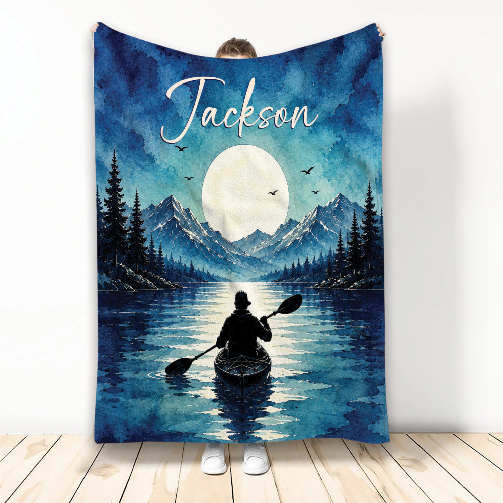 Kayak throw blanket with a moonlit mountain lake, pine trees, blue watercolor scenery, and paddler artwork