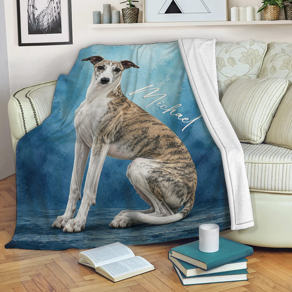 Whippet throw blanket displayed on a sofa with blue dog artwork and cozy reading decor