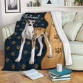 Whippet throw blanket draped over a sofa with paw-print pattern and brindle dog artwork