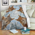 Squirrel blanket draped over a sofa with playful woodland artwork and snowy branches