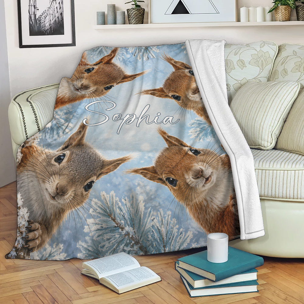 Squirrel blanket draped over a sofa with playful woodland artwork and snowy branches