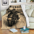 Biker throw blanket displayed on a sofa with motorcycle rider and mountain road artwork