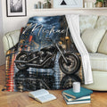 Biker throw blanket displayed on a sofa with dramatic motorcycle and urban night artwork