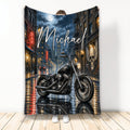 Biker throw blanket featuring a black motorcycle on a rainy neon-lit city street at night