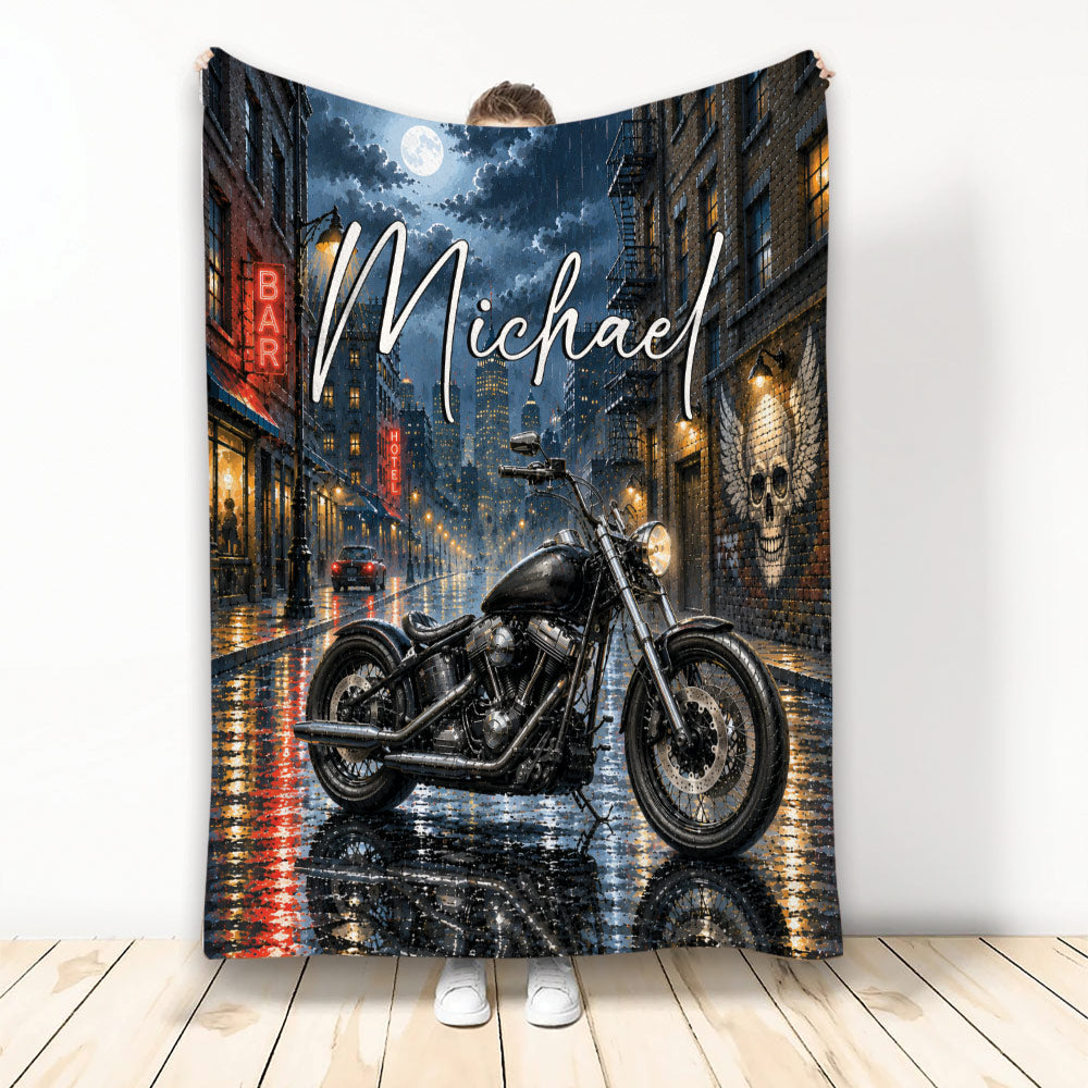 Biker throw blanket featuring a black motorcycle on a rainy neon-lit city street at night