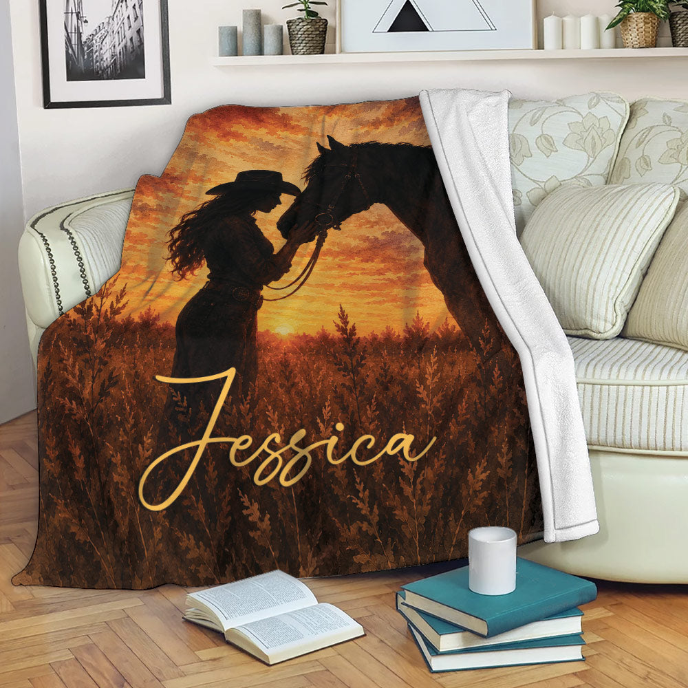 Cowgirl and horse throw blanket styled on a sofa with rustic sunset artwork