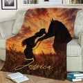 Rustic cowgirl and horse blanket draped across a sofa with warm Western landscape artwork