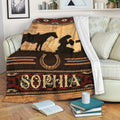 Custom cowgirl blanket displayed on a sofa with Western horse, horseshoe, and rustic sunset artwork