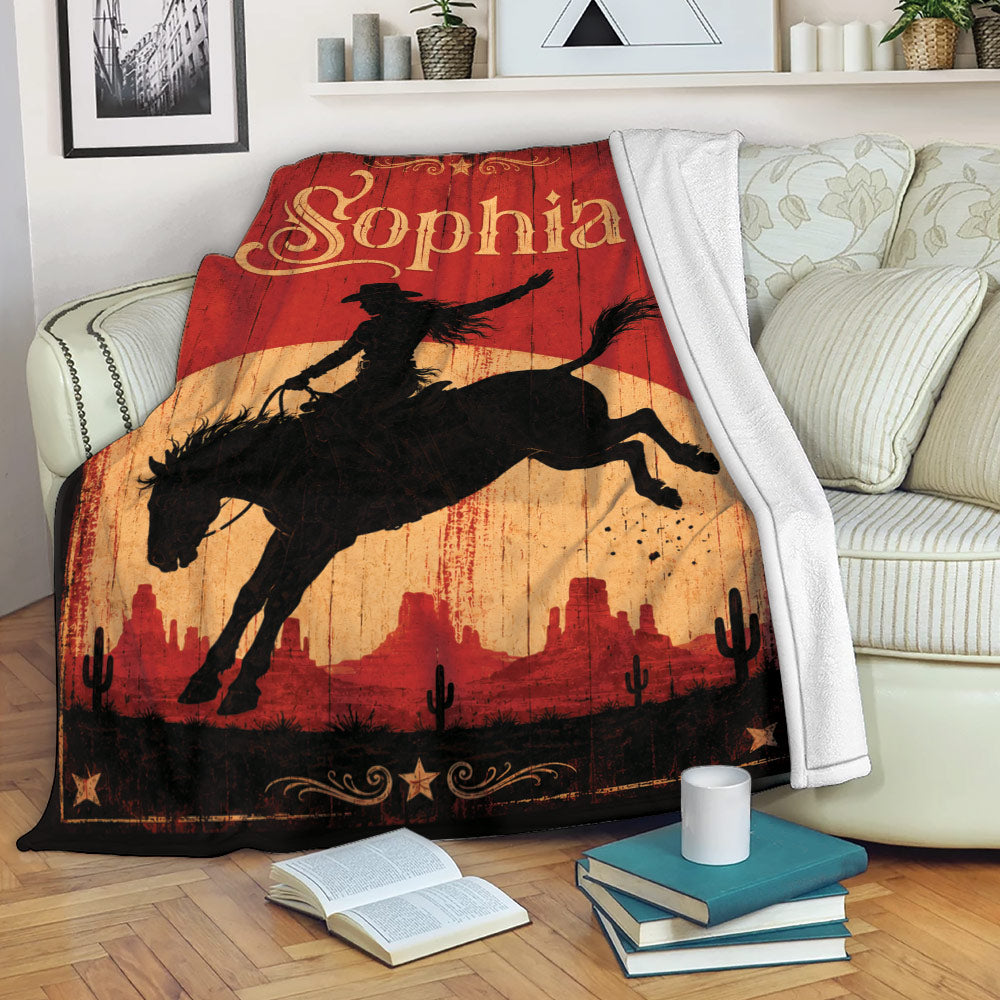 Cowgirl throw blanket draped over a sofa with Western rodeo artwork and desert landscape