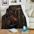 Violin blanket draped across a living room sofa beside books and a coffee mug