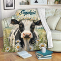 Floral cow throw blanket draped across a sofa in a cozy living room