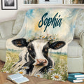 Cow blanket with meadow flowers and watercolor artwork styled on a sofa