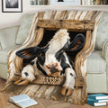 Black and white cow throw blanket displayed on a sofa with weathered wood and farmhouse details
