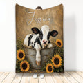 Cow throw blanket featuring a black-and-white calf in a metal tub surrounded by sunflowers