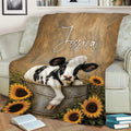 Rustic cow throw blanket draped over a sofa with calf and sunflower farmhouse artwork